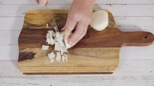 Mincing Organic Yellow Onion on a Wood Cutting Board