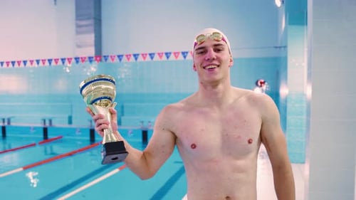 Portrait of a Winning Athlete Swimmer with a Won Cup in the Pool The Winning Man Rejoices and Enjoys