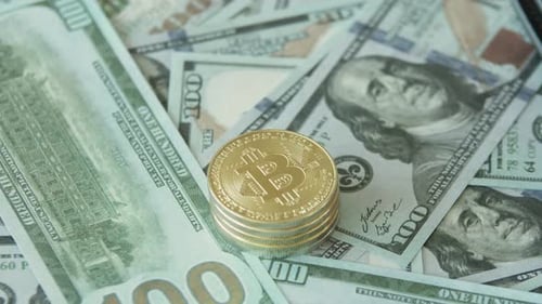 A Lot of Hundreddollar Bills with a Gold Bitcoin Lying on Top