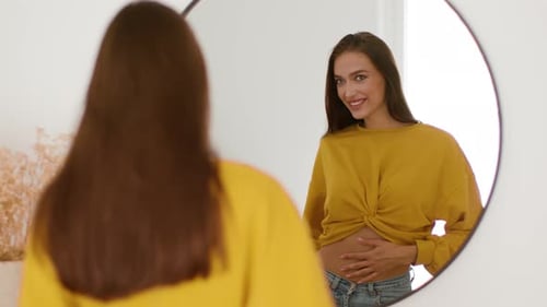 Smiling Woman Checks Her Appearance in Mirror
