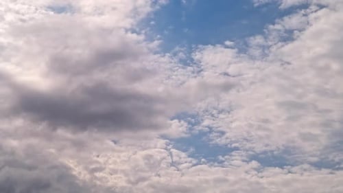 Fluffy White Clouds Moving Across the Blue Sky