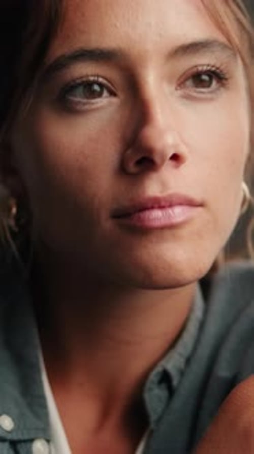 Vertical video, Close-up of a pensive young woman sitting in the living room by the window
