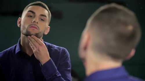 Young Man Checks Appearance in Mirror