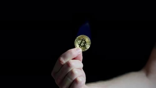 Burning Bitcoin Held in Hand Close Up