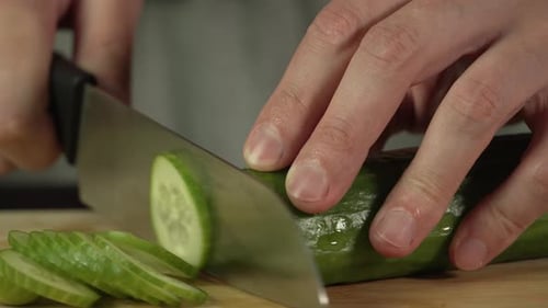 Cucumber Slices Being Cut in Kitchen