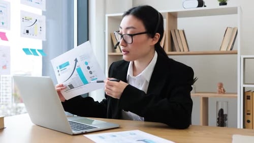 Young Adult Presents Graphs in Office Setting