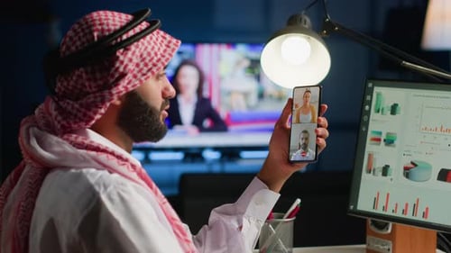 Man in Traditional Dress Works with Technology