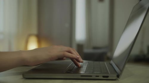 Hands Typing on Laptop Keyboard in Home