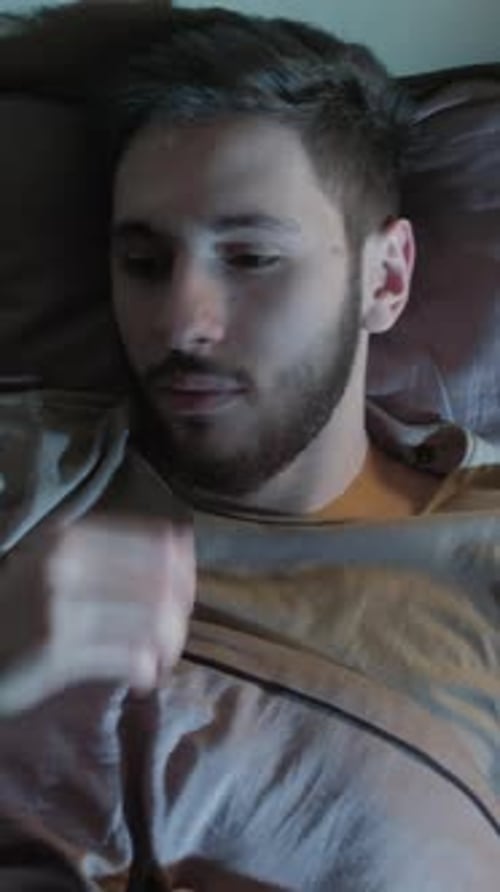 Man Waking Up From Sleep in Dark Bedroom