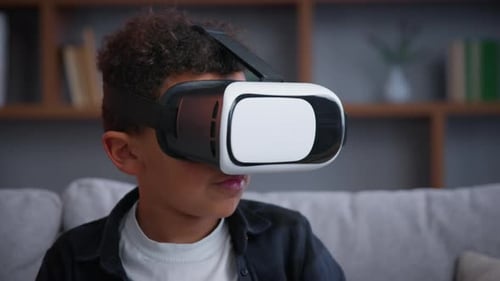 Boy Wearing VR Headset Reaching Upward in Living Room