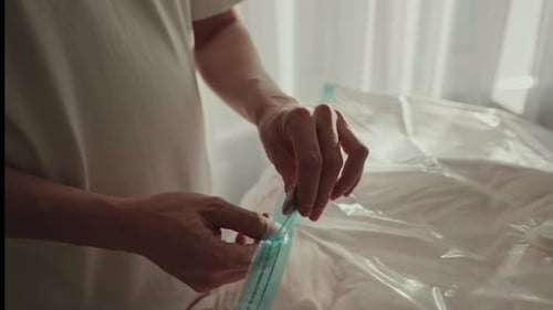 Hands Zipping Plastic Vacuum Storage Bag