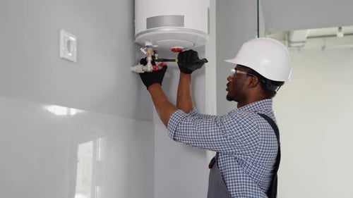 Plumber Using Wrench While Fixing Boiler or Water Heater Boiler Service Maintenance Concept Repair