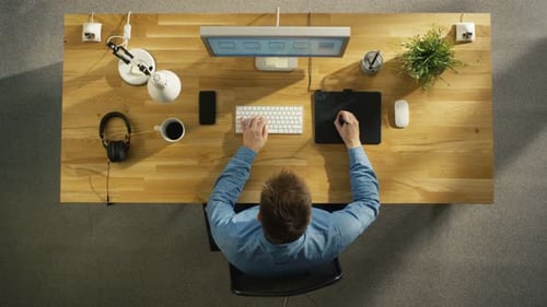 Graphic Designer Working at Computer Overhead Angle