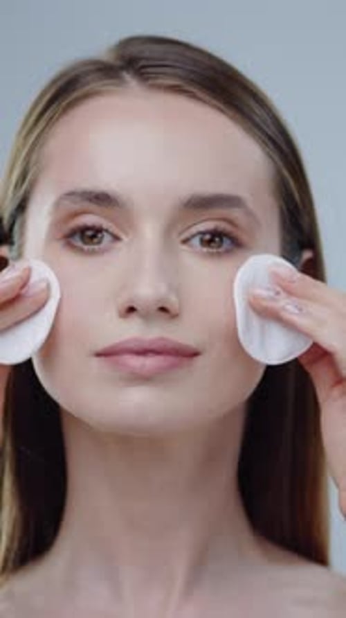 Woman Cleans Face with Cotton Pads, Smiling