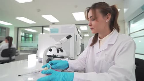 Woman Scientist Using Microscope in Research Lab