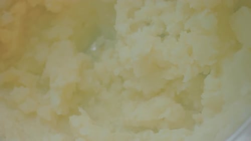 Le chef broie la purée de pommes de terre, de la vapeur sort des pommes de terre