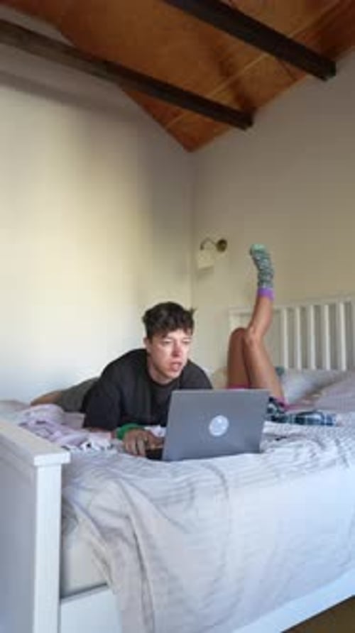 Enjoying Relaxed WorkfromHome Vibes with a Laptop While Comfortably Laid in Bed