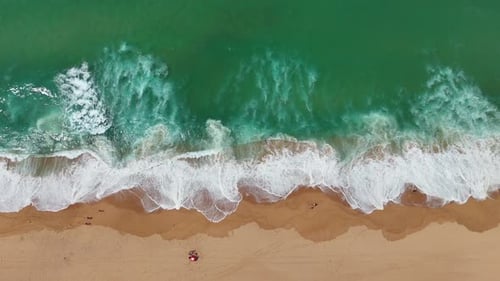 A Stunning Aerial View Showcasing the Beautiful Turquoise Waves and the Sandy Beach Area