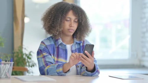 Woman Uses Phone at Desk in Bright Home