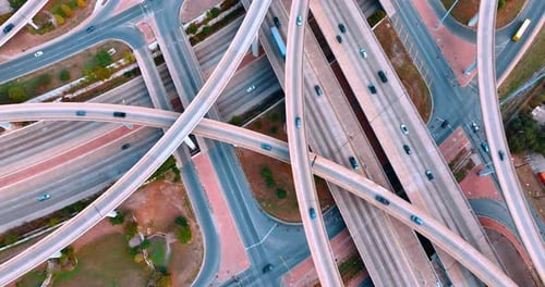 Cars run by the multi-level interchange. Transportation and logistics concept. Top view.