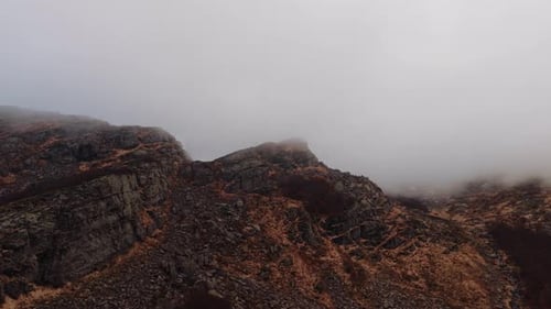 Aerial view of fog-covered rocky slopes in the Dolomites Mountains, Italy