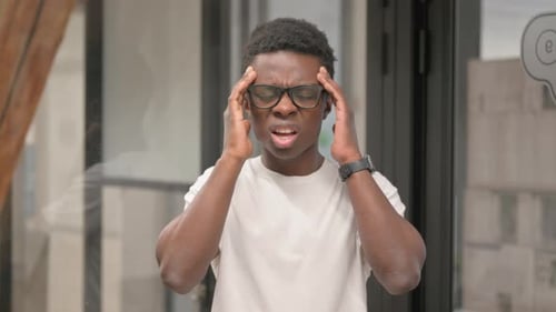 Portrait of Casual Young African Man with Headache in Office