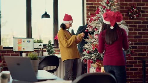 Diverse Group of People Decorating Office with Christmas Ornaments