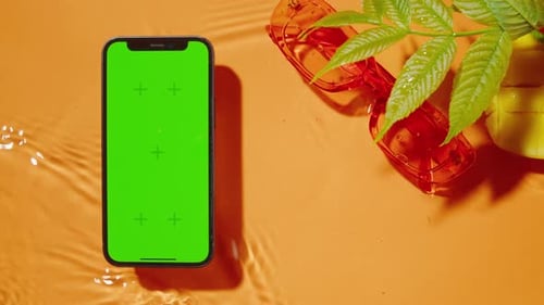 Phone with Green Screen Chroma Key on Orange Background Composition of Smartphone Cell Phone