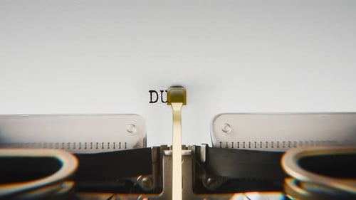 Old mechanical typewriter typing Duty in a close-up view.