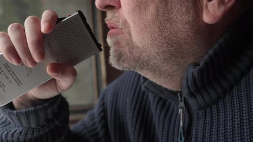 Close Up Side Profile of Man Speaking Emotionally into Retro Dictaphone