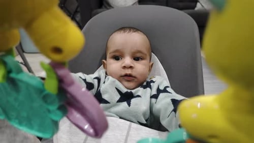 Baby Boy Sitting in Bouncer Seat