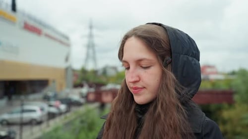 Thoughtful Woman Walking Alone on City Bridge Solitary Woman with Long Hair in Wool Coat Reflecting