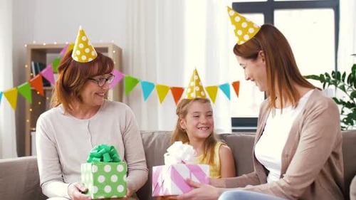 Three Females Celebrate Birthday with Gifts and Party Hats