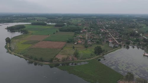 Aerial View Of A Serene Landscape With Fields Water Bodies And A Small Town