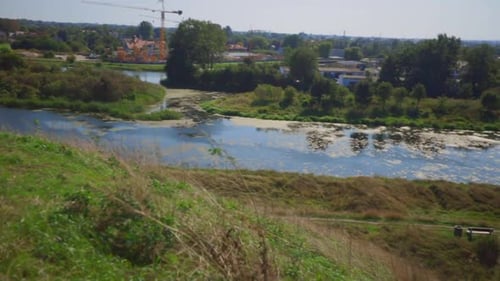 Beautiful river with moss,landscape and Gdansk City during sunny day in Poland.Pan panorama shot.