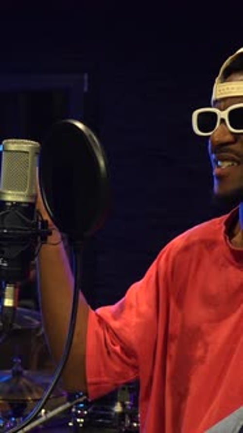 Young stylish artist recording music in studio