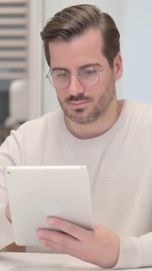 Young Man Using Digital Tablet in Office