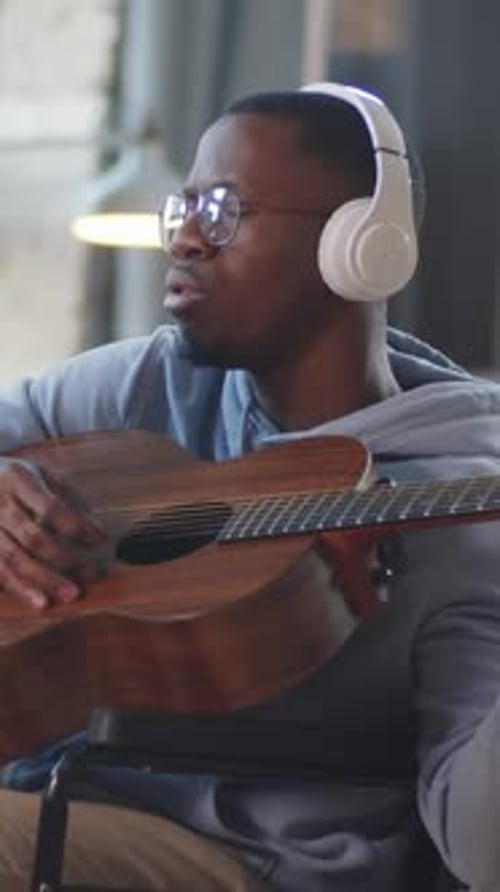 Man in Wheelchair Playing Guitar in Studio