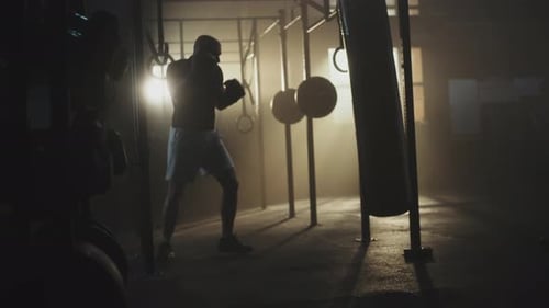 Boxer hits punching bag at gym