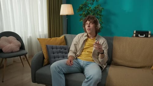 Young Man Listening and Dancing to Music At Home