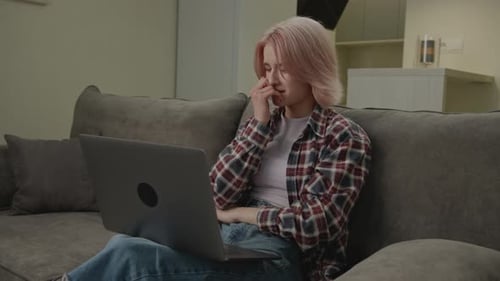 Woman Works on Laptop, Gets Upset on Sofa