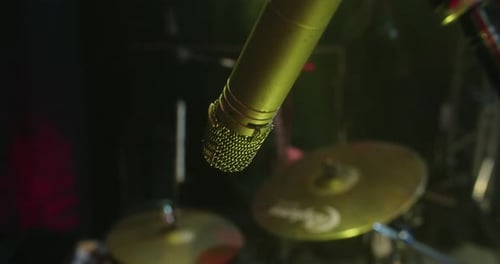 Drum microphone recording during a sound check on an empty stage with yellow lights. 4K