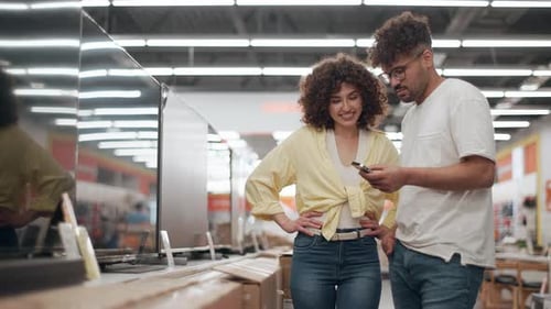 Customers choosing television in electronics store in slow motion