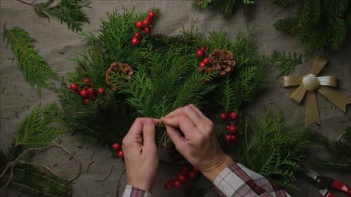 Hands Crafting a Holiday Wreath for Christmas