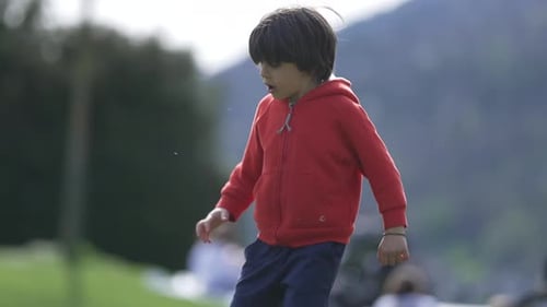 Kleines Kind läuft in einem Park, Seitenprofil, genießt aktive Spielzeit, Frühlingssaison, energisch