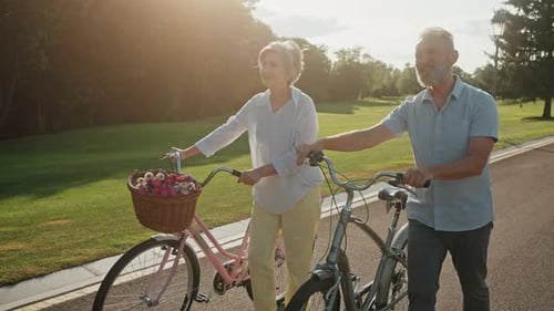 Senior Active Couple Enjoying Romantic Walk with Bicycles