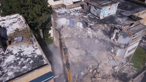 A Huge Heavy With Demolition Crane In The City With Old Buildings. Aerial Shot