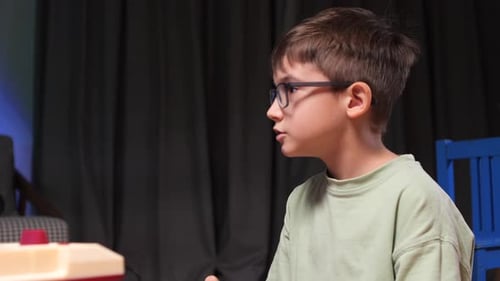 Young Boy Playing Retro Video Game Console Using a Joystick at Home