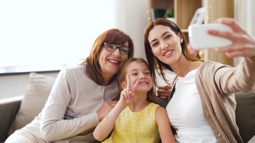 Three Females Posing for Selfie on Couch Indoors