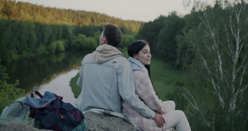 Slow Motion of Man and Woman Married Couple Sitting on Rock in Mountain Forest Watching River
